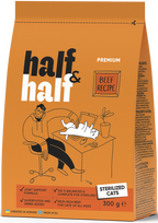 A brown bag of Half&Half Premium Beef Recipe dry cat food for sterilized cats is displayed. The packaging features a cartoon illustration of a person sitting at a desk with a cat lying on their lap, along with nutritional information.